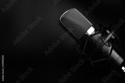 Condenser black studio microphone on a black background. Streamer, podcasts, music background