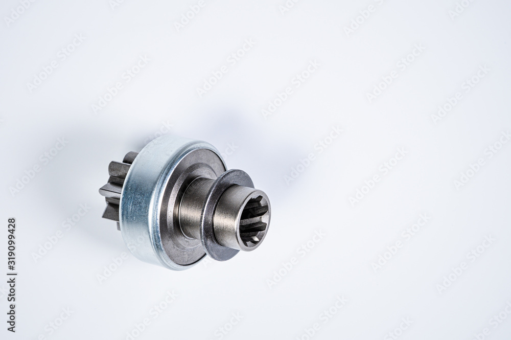 New spare parts - starter gear drive for motor starter on a gray background. Classic gear transmission via torque transmission New spare parts - starter gear drive for motor starter on a gray background. Classic gear transmission via torque transmission