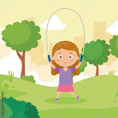 cute little girl jumping rope in park landscape