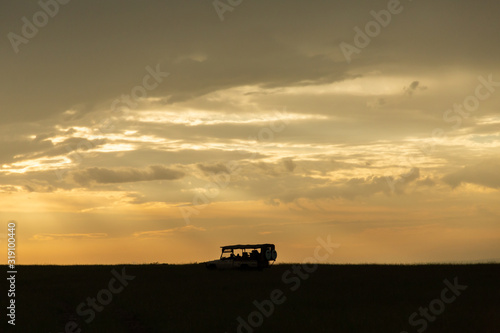 silhouette of a jeep on the savannah at sunrise © lindacaldwell