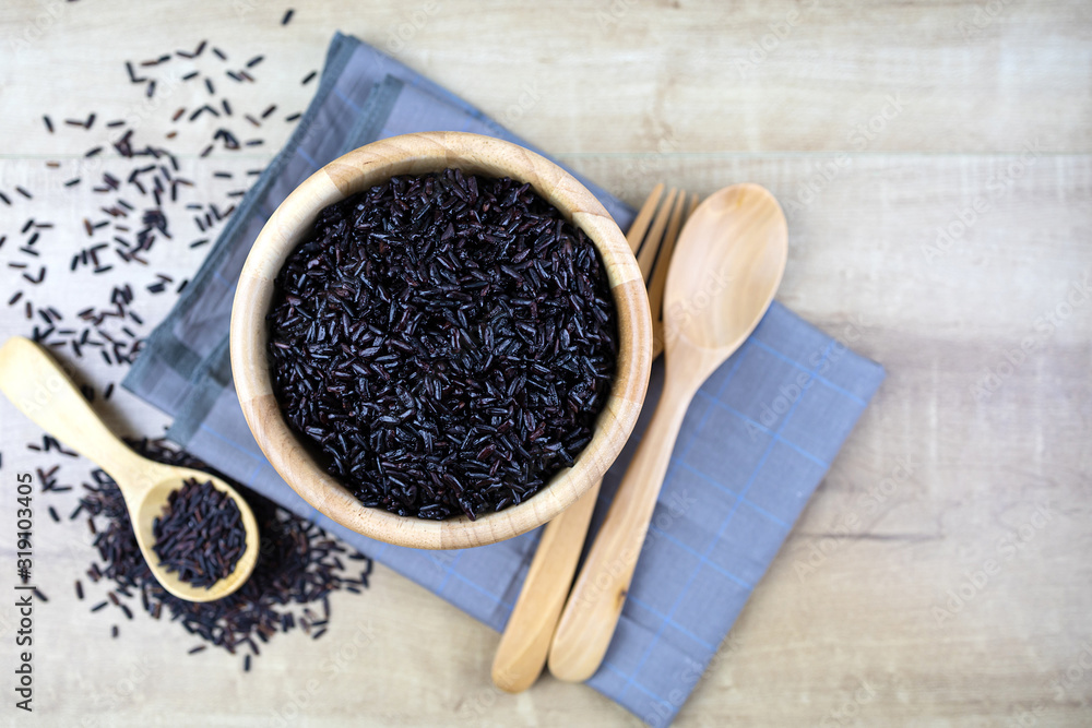 Riceberry cooked in a wooden cup Wooden spoons and wooden forks placed on fabric. Riceberry cooked in a wooden cup Wooden spoons and wooden forks placed on fabric.