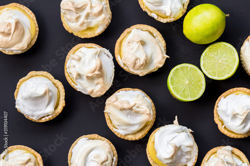 Lemon meringue tartlets made with lime isolated on black surface - overhead image close up photo