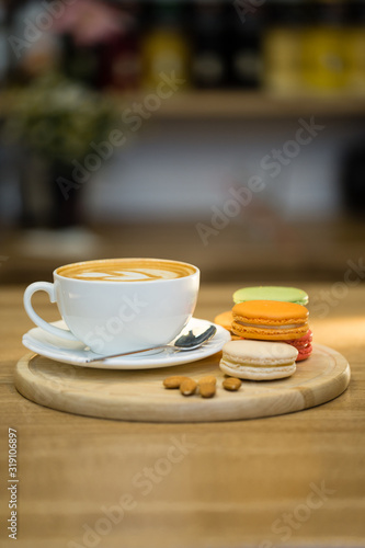 Cup of cappuccino coffee with macaroons and nuts on wooden table © polinabelphoto