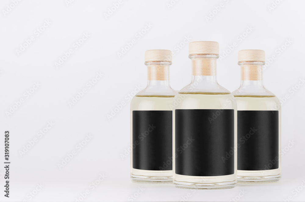 Group glass bottles for cosmetic, perfume, alcohol drink with black label, cork, yellow liquid on white background, mock up for design. Group glass bottles for cosmetic, perfume, alcohol drink with black label, cork, yellow liquid on white background, mock up for design.
