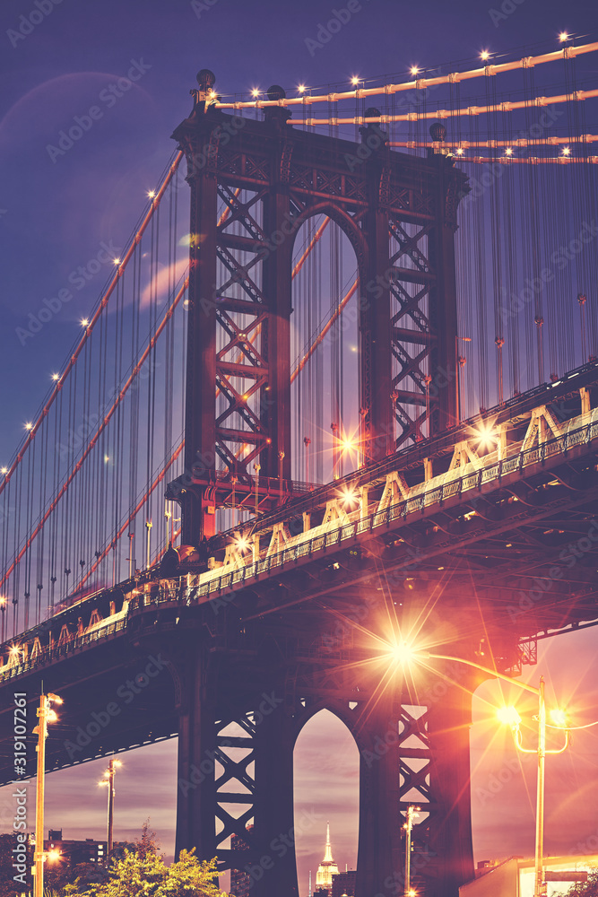 Fototapeta Manhattan Bridge with lens flares seen from Brooklyn at dusk, color toned picture, New York, USA.