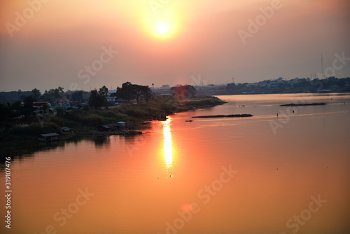 Sunset at the Chao Phraya River at Dechatiwong Bridge, Nakhon Sawan city Thailand. photo