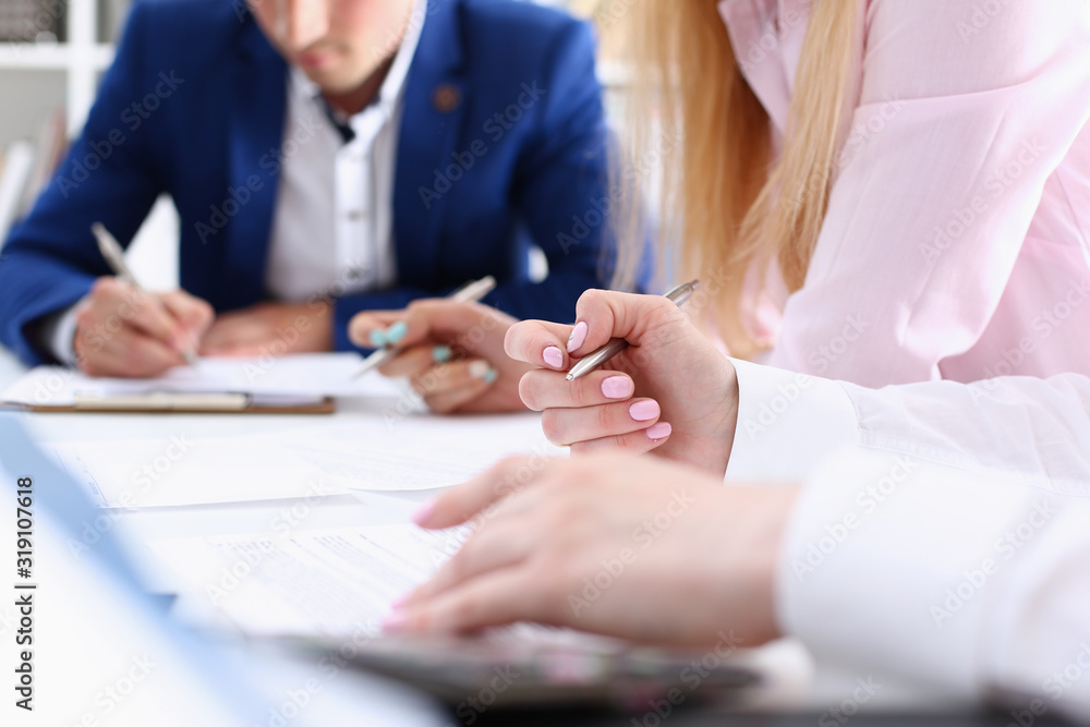 Group of people hold silver pen ready to make note in clipboard pad sheet closeup. Training course university practice homework school or college exercise secretary table management concept