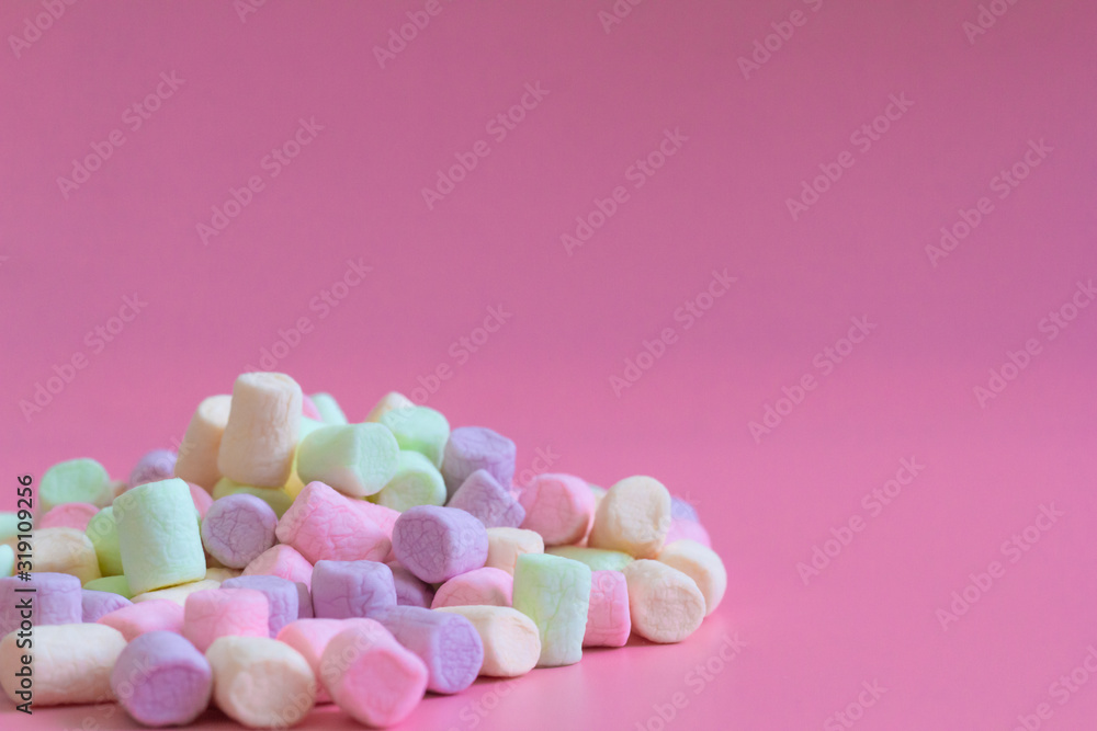 Colorful marshmallows on pink background, macro. Fluffy marshmallows texture close up in pastel colors Colorful marshmallows on pink background, macro. Fluffy marshmallows texture close up in pastel colors