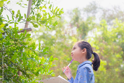 Little cute girl checking vegetable and writing record document in a farm, Learning outside the classroom concepts.