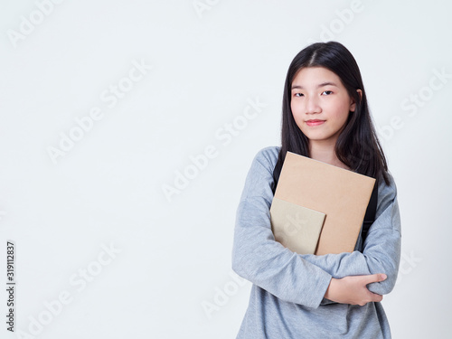 Girl student holding books with backpacks.