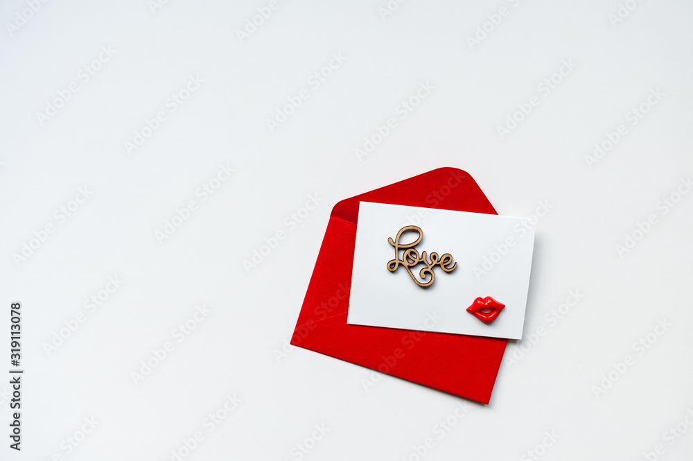 Red envelope and blank postcard with word Love on white background. Valentine's Day concept. Minimalism, copy space, top view.