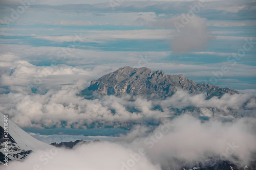 Landscape of the mountain in the white fluffy clouds
