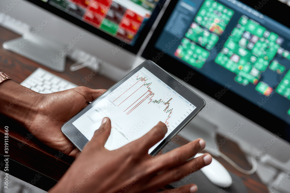 For the things you need. Close up shot of hands holding tablet pc. Trader is using touch screen tablet for analyzing stock market chart, while working in the office For the things you need. Close up shot of hands holding tablet pc. Trader is using touch screen tablet for analyzing stock market chart, while working in the office