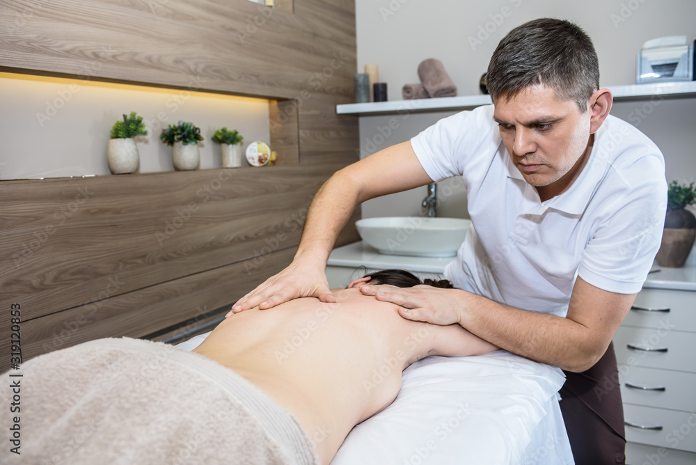 Woman getting classical back and neck massage Stock Photo by