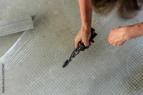 Worker cuts a metal grid at a construction site.