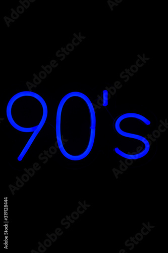Blue 90's neon sign on isolated black background. Neon concept. Modern style. Neon sign. Flat lay, copy space, top view. 