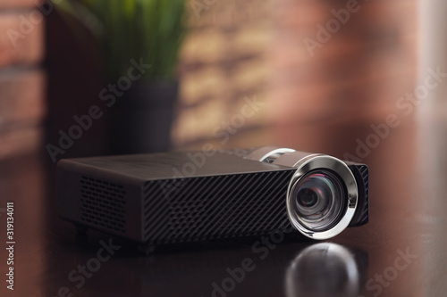 Modern video projector on wooden table indoors photo