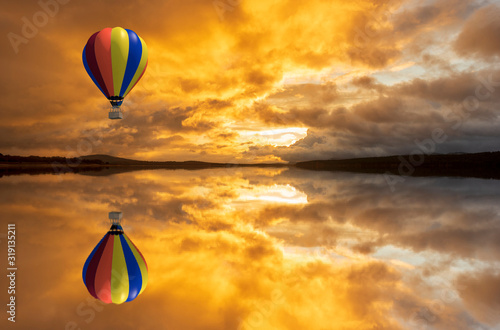 A hot air balloon over a lake at sunrise