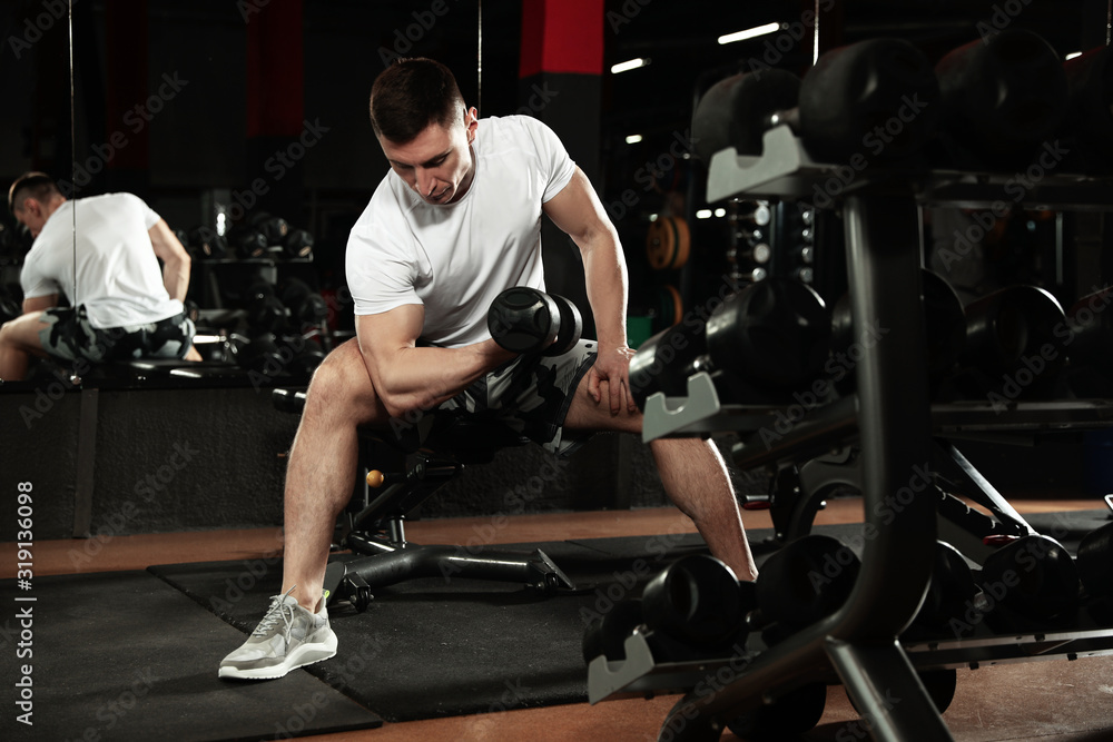 Man working out with dumbbell in modern gym Man working out with dumbbell in modern gym