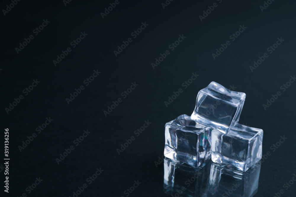 Crystal clear ice cubes on black background. Space for text Crystal clear ice cubes on black background. Space for text