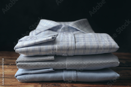 Stack of classic shirts on wooden table