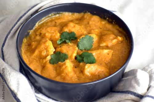 Chicken Korma on a black bowl. Traditional Indian food. Selective focus.