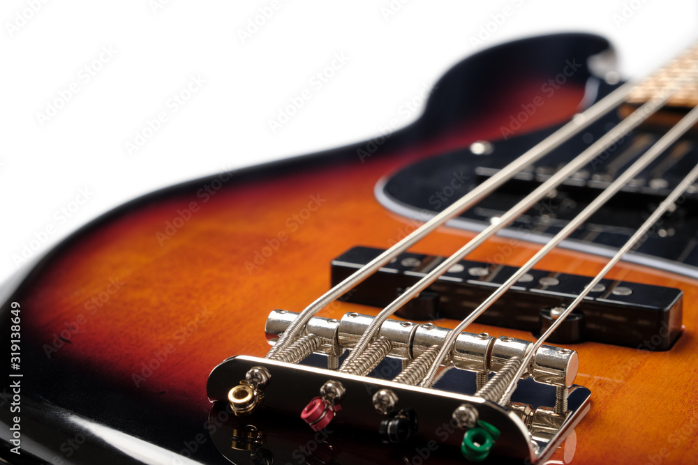 Close Up to the bridge and body part of Sunburst 4 string jazz bass guitar isolated on white background. Close Up to the bridge and body part of Sunburst 4 string jazz bass guitar isolated on white background.
