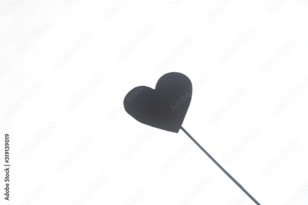 heart shadow on a stick on a textured white background
