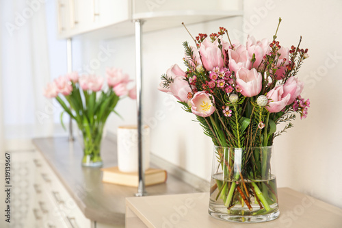 Beautiful bouquet with spring pink tulips on table indoors. Space for text