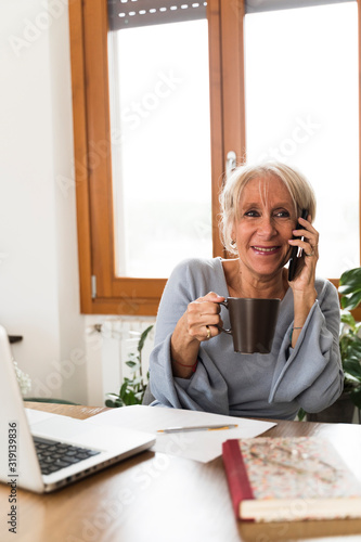 Business adult woman talking to the phone at home