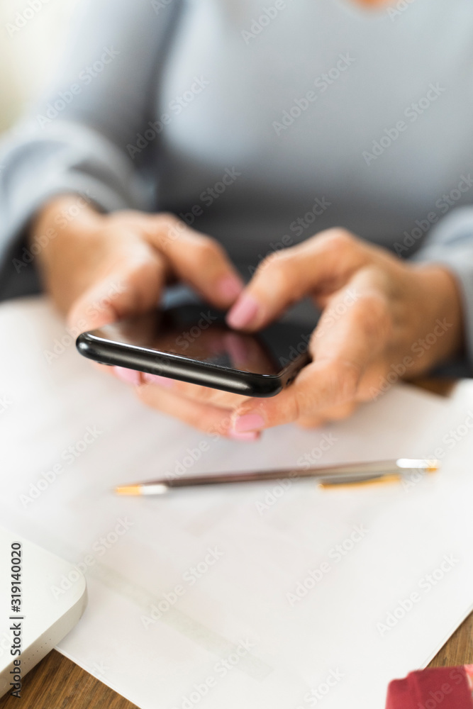 Fototapeta premium businesswoman typing a message on her mobile phone