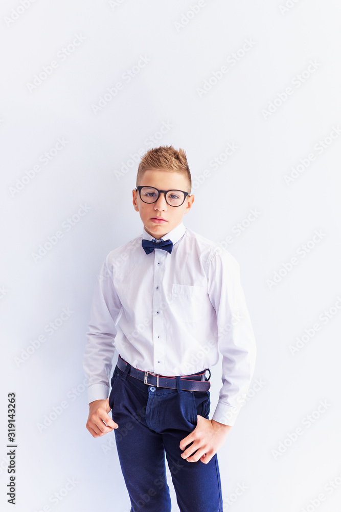 A small cheerful, cute, fashionable blond boy with glasses looks at the camera trying on glasses.The concept of health. Vision correction. Ophthalmology. A small cheerful, cute, fashionable blond boy with glasses looks at the camera trying on glasses.The concept of health. Vision correction. Ophthalmology.