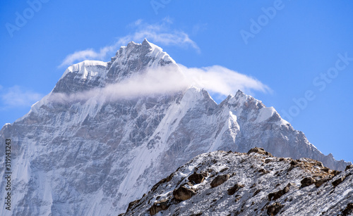 Majestic Thamserku (6652 m) peak towering above the clouds at sunrise in Nepal, Himalayan mountains