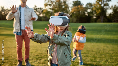 Digital weekend. Family playing in virtual reality glasses outdoors © Svitlana