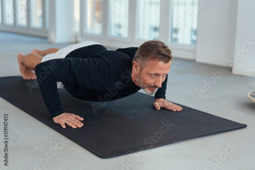 Man working out doing press ups in a gym