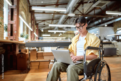 Quadro em tela Talent wins. Guy in a wheelchair working in the office