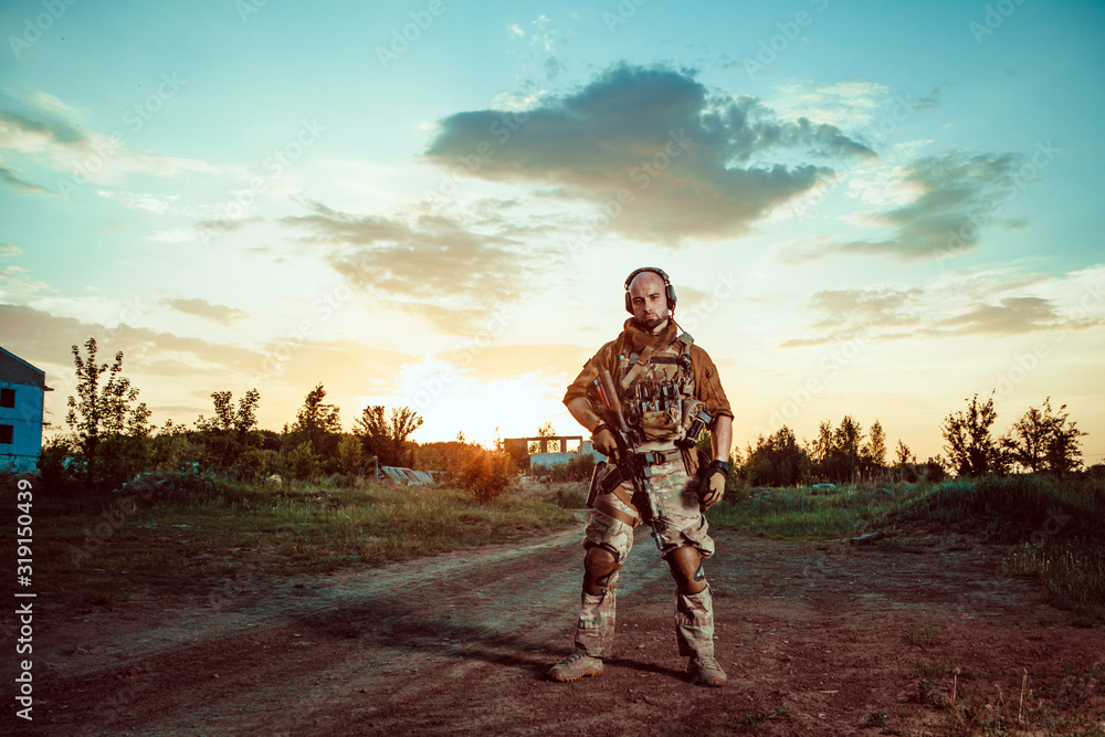 American soldier with the M4 rifle on the ruined town background. American soldier with the M4 rifle on the ruined town background.