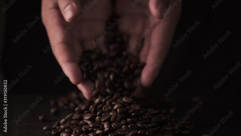 slow motion of hands pouring coffee beans to a pile of coffee beans. slow motion of hands pouring coffee beans to a pile of coffee beans.