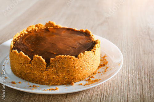 Homemade caramel cheesecake on wooden background
