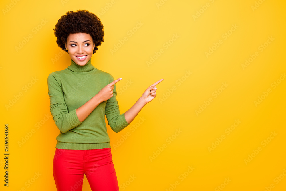 Photo of curly wavy cheerful positive girlfriend with forefingers pointed to the empty space in red trousers showing account to follow isolated bright color background