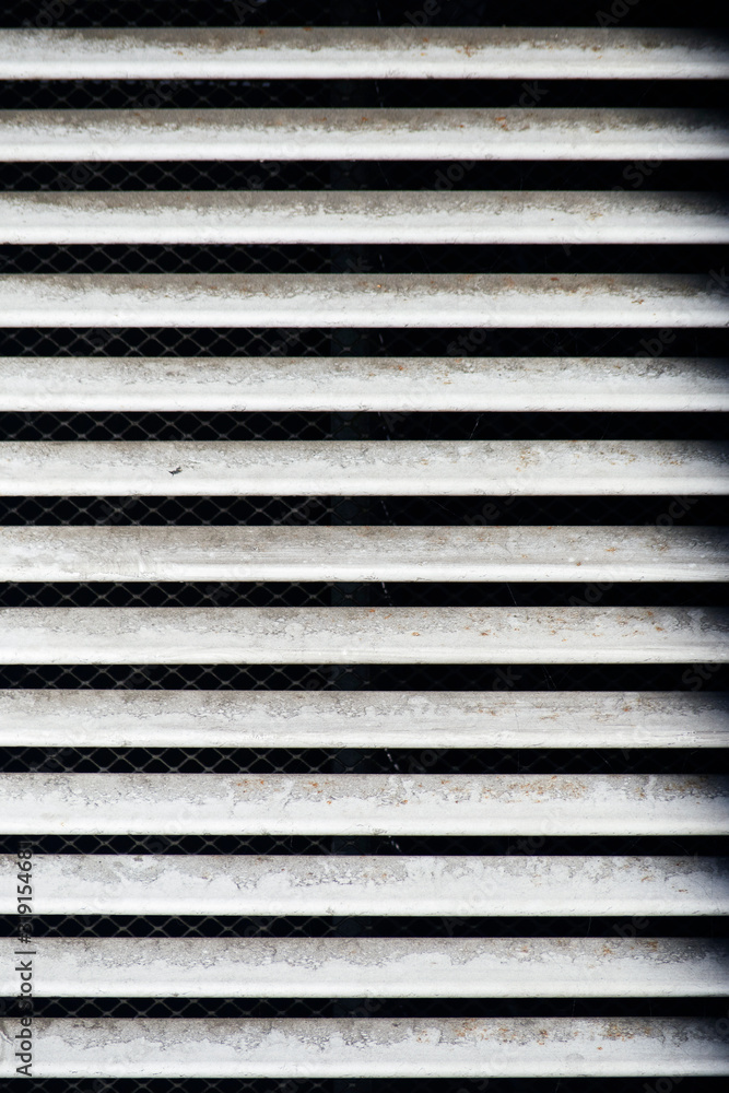 Obraz premium Industrial vent white dirty grill texture with parallel horizontal aluminium inclined shutters planks with net in the far side