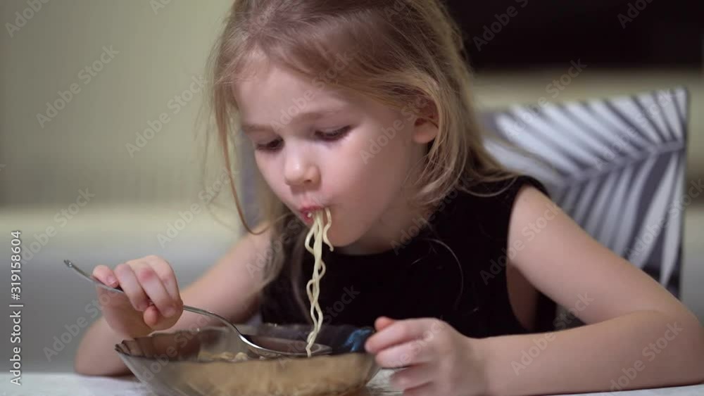 Little hairy girl eating noodles. Stock Video | Adobe Stock