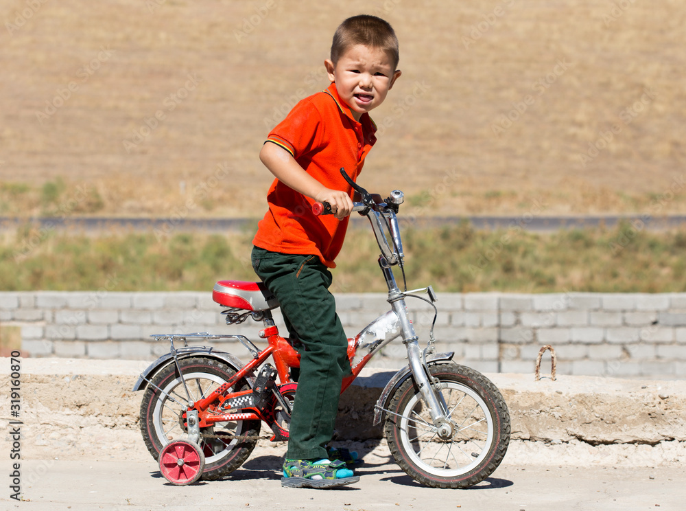 Little toddler boy learning to ride on his first bike Little toddler boy learning to ride on his first bike