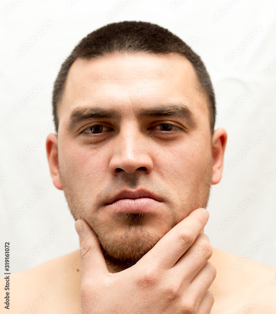 Obraz premium man thinks shave his beard or not