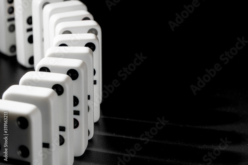 Domino pieces put in a row on black background photo