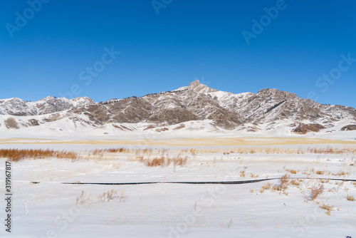 Snow mountain and snow field grassland near by the Xinjiang China Sayram lake. Winter season.