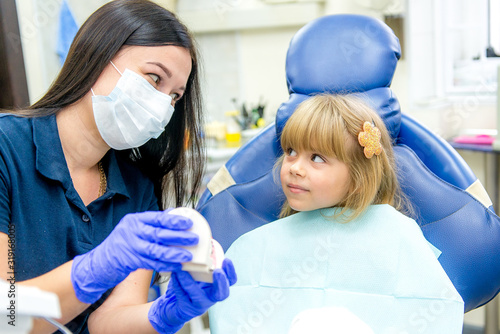 Little girl sitts in the dentist's office