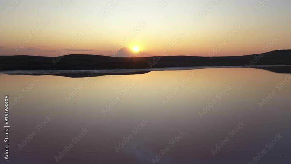 The famous Koyashsky lake in the evening, shot down from above by a drone. Amazing lake against the backdrop of the sunset in Crimea, Ukraine. Salt, clear and mineral lake top view in slow motion. The famous Koyashsky lake in the evening, shot down from above by a drone. Amazing lake against the backdrop of the sunset in Crimea, Ukraine. Salt, clear and mineral lake top view in slow motion.