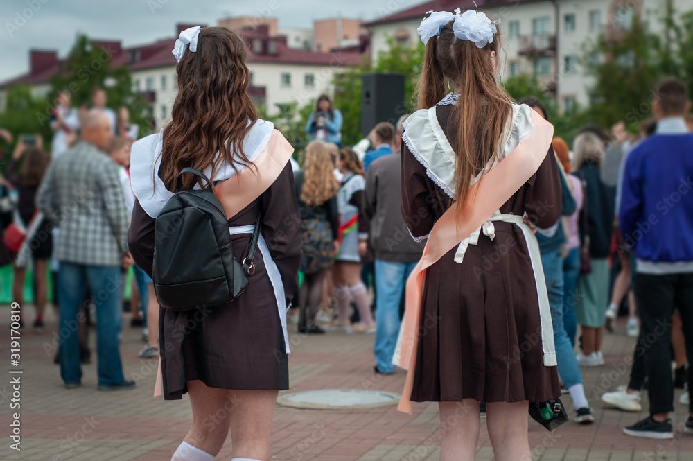 Girls graduates of the school in a beautiful uniform with red ribbons at the graduate parade. Last call. Girls graduates of the school in a beautiful uniform with red ribbons at the graduate parade. Last call.