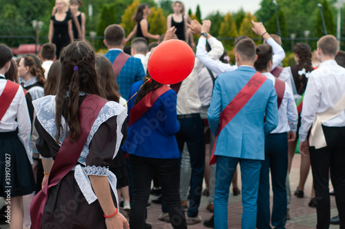 Belarus, Bobruisk - May 30, 2019. School graduate girl in beautiful uniform at the graduates parade with an inflatable red ball in hand. Last call.